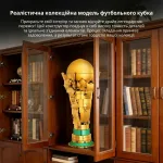 Зібрана колекційна модель футбольного кубка золотистого кольору на полиці в інтер’єрі вітальні