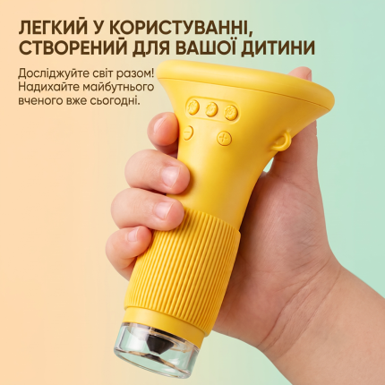 Дитяча рука тримає легкий жовтий цифровий мікроскоп, демонстрація зручного ергономічного дизайну для маленьких дослідників та рекламний напис українською мовою