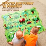 Діти граються розвиваючим інтерактивним трек-пазлом Лісопарк з авто, складаючи маршрут на килимі