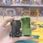 Знятий корпус і відкритий відсік для батарейки типу ААА в зеленому позашляховику до трек-пазла Парк динозаврів